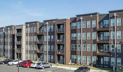 a large brick building with cars parked in a parking lot at Bright & Cozy Near TQL & Paycor Stadiums in Cincinnati