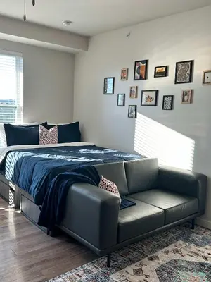 a bed and a couch in a bedroom at Bright & Cozy Near TQL & Paycor Stadiums in Cincinnati