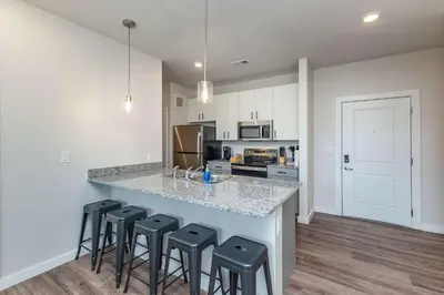 a kitchen with a counter and stools in a room at Stylish & Spacious Stay Near The Banks in Cincinnati