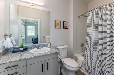 a bathroom with a toilet and a sink and a mirror at Modern Stay Close to Dining & Entertainment in Cincinnati