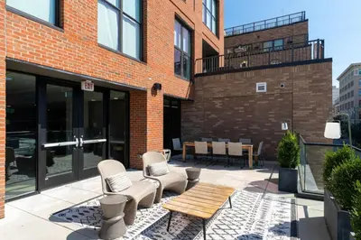 a patio with two chairs and a wooden table at OTR 1 Bed Suite Free Parking Gym Pool Clubroom in Cincinnati