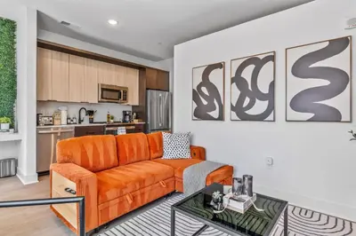 a living room with an orange couch and a table at OTR King Bed Free Parking Gym Top Floor Club Room in Cincinnati