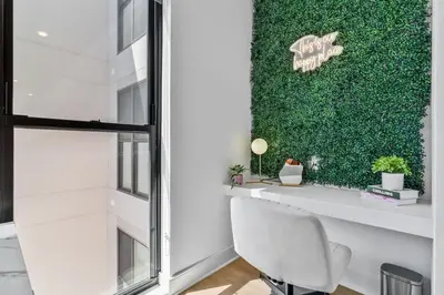 a white chair in a room with a green wall at OTR King Bed Free Parking Gym Top Floor Club Room in Cincinnati