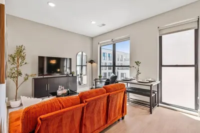 a living room with orange chairs and a table at OTR King Bed Free On Site Parking Gym Pool Club Room in Cincinnati