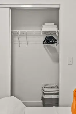 a closet with a bed and towels on a shelf at OTR King Bed Free On Site Parking Gym Pool Club Room in Cincinnati