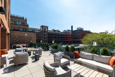 a rooftop patio with couches and tables and chairs at OTR King Bed Free On Site Parking Gym Pool Club Room in Cincinnati