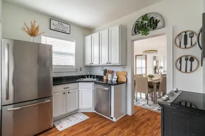 a kitchen with white cabinets and a stainless steel refrigerator at Luxury Short and Midterm Hyde Park Getaway in Cincinnati
