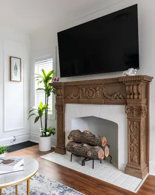 a living room with a fireplace with a television above it at Luxury Short and Midterm Hyde Park Getaway in Cincinnati