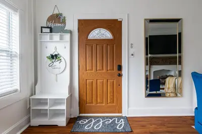 a room with a wooden door with a clock on the wall at Luxury Short and Midterm Hyde Park Getaway in Cincinnati