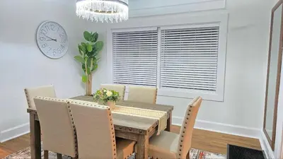 a dining room with a table and chairs and a clock at Luxury Short and Midterm Hyde Park Getaway in Cincinnati