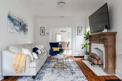 a living room with a white couch and a fireplace at Luxury Short and Midterm Hyde Park Getaway in Cincinnati