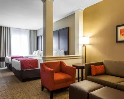 a hotel room with a bed and a chair at Comfort Suites-Youngstown North in Youngstown