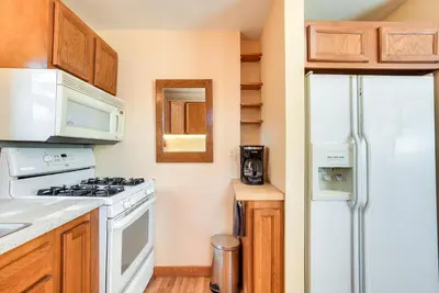 a kitchen with a white stove top oven next to a refrigerator at Quiet and Idyllic Studio Near Glen Helen Preserve in Fairborn