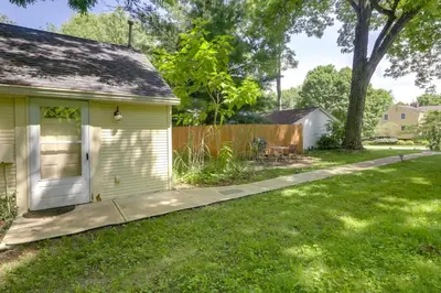 a yard with a small yellow house and a fence at Quiet and Idyllic Studio Near Glen Helen Preserve in Fairborn