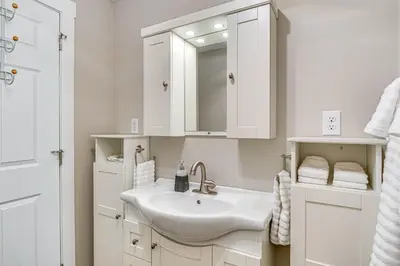 a white bathroom with a sink and a mirror at 15 Mi to Summit Lake State Park Updated Apt! in Hagerstown