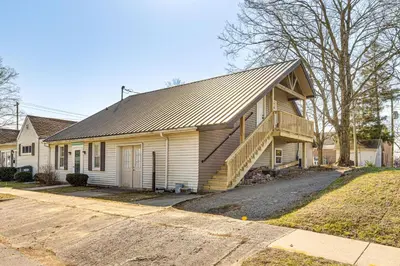 a white house with a gambrel roof with a staircase at 15 Mi to Summit Lake State Park Updated Apt! in Hagerstown