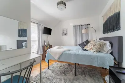 a bedroom with a bed and a desk and a window at Kenmore Akron 3 bedroom 1 bath in Akron