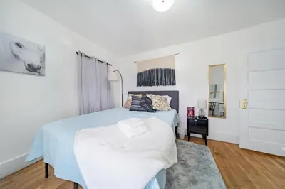 a white bedroom with a bed and a window at Kenmore Akron 3 bedroom 1 bath in Akron