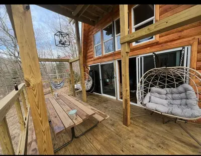 a porch with a swing and a bench on a cabin at Cabin in the treetops! in Lancaster
