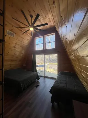 a room with two beds and a ceiling fan at Cabin in the treetops! in Lancaster
