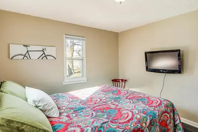 a bedroom with a bed and a tv on the wall at 2 Mi to UD Pet-Friendly Home with Fenced Yard! in Dayton
