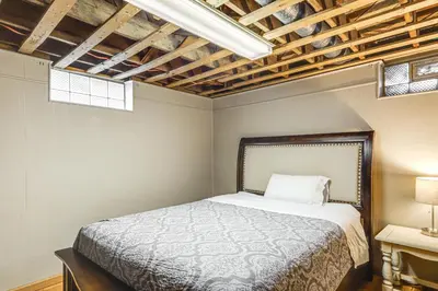 a bedroom with a bed and two windows at 2 Mi to UD Pet-Friendly Home with Fenced Yard! in Dayton