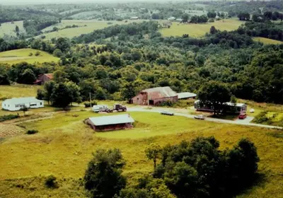 an aerial view of an open field with a farm at Cozy Tiny House on Working Farm, for Fun Glamping Trips in Kentucky in Owenton
