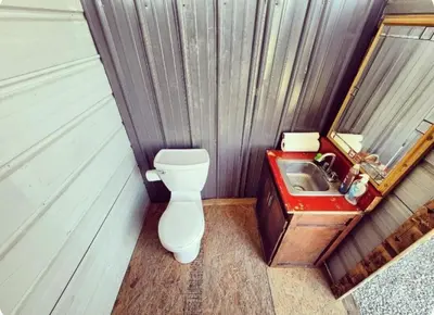 a small bathroom with a toilet and a sink at Cozy Tiny House on Working Farm, for Fun Glamping Trips in Kentucky in Owenton