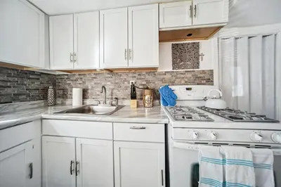 a white kitchen with a sink and a stove at 3 bedroom 1 bath in Cleveland in Cleveland