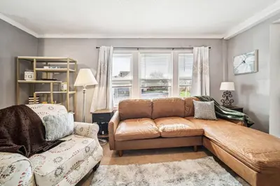 a living room with a brown leather couch and a chair at 3 bedroom 1 bath in Cleveland in Cleveland