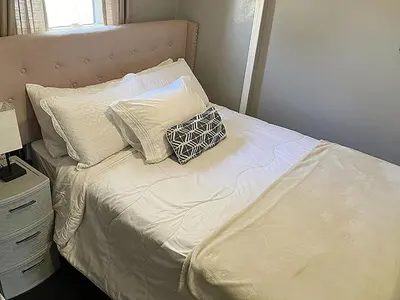 a bed with white sheets and pillows on it at 3 bedroom 1 bath in Cleveland in Cleveland
