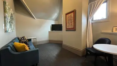 a living room with a blue chair and a table at Stone Gables Inn in Cleveland