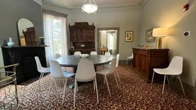 a dining room with a table and white chairs at Stone Gables Inn in Cleveland