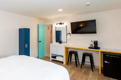 a bedroom with a bed and a desk with two stools at HomeField Inn in Sandusky