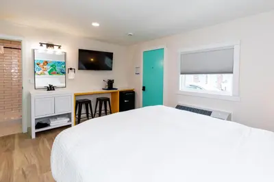 a bedroom with a white bed and a flat screen tv at HomeField Inn in Sandusky