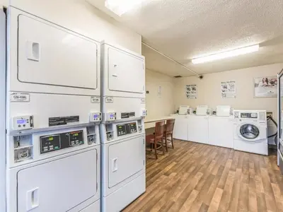 a laundry room with white machines and a table at Siegel Select Cincinnati Sharonville in Cincinnati