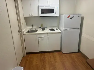 a small kitchen with a refrigerator and a microwave at Siegel Select Cincinnati Sharonville in Cincinnati