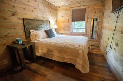 a bedroom with a bed in a wooden cabin at Serenity Ridge- Scenic Luxury Log Estate Getaway in McArthur