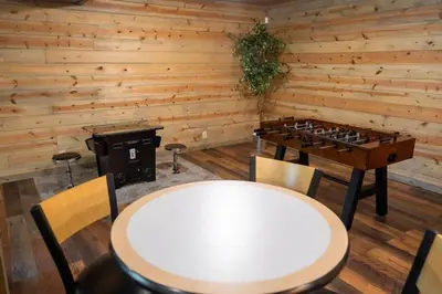 a ping pong table and chairs in a room with wooden walls at Serenity Ridge- Scenic Luxury Log Estate Getaway in McArthur