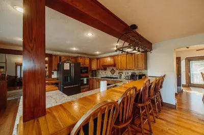 a large kitchen with a long wooden table and chairs at Majestic Home in Hocking wPool Jacuzzi Basketball in McArthur