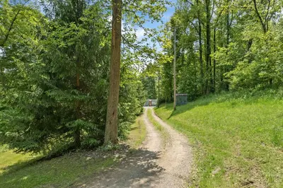 a dirt road in the middle of a forest at Unique Dover Accommodation with a Hot Tub Perfect for Glamping in Ohio in Dover