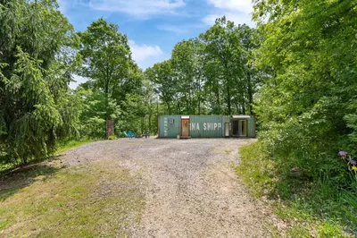 a building on a dirt road in a forest at Unique Dover Accommodation with a Hot Tub Perfect for Glamping in Ohio in Dover