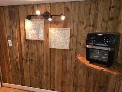 a microwave on top of a wooden wall at The Happy Place in Glouster