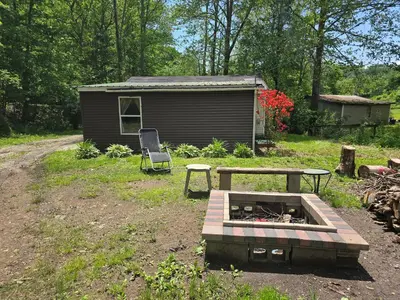 a picnic table and a bench in front of a shed at The Happy Place in Glouster