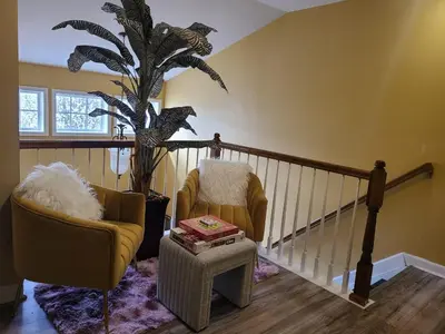 a living room with two chairs and a plant at Charming Escape Haven in Lexington