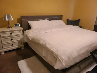 a bedroom with a white bed and a night stand at Charming Escape Haven in Lexington