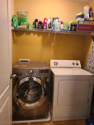a laundry room with a washing machine and a shelf at Charming Escape Haven in Lexington
