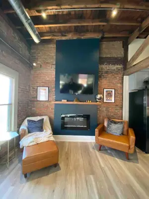 a living room with two chairs and a fireplace at Condo in OTR, Pendleton Art District in Cincinnati