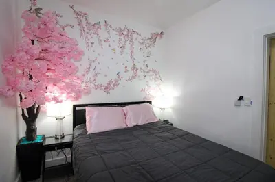 a bedroom with a bed and a tree with pink flowers at The Wilderness, Near CP & SF, W&D, Pet OK in Sandusky