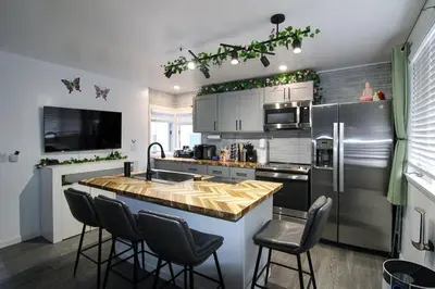 a kitchen with a counter with chairs and a refrigerator at The Wilderness, Near CP & SF, W&D, Pet OK in Sandusky